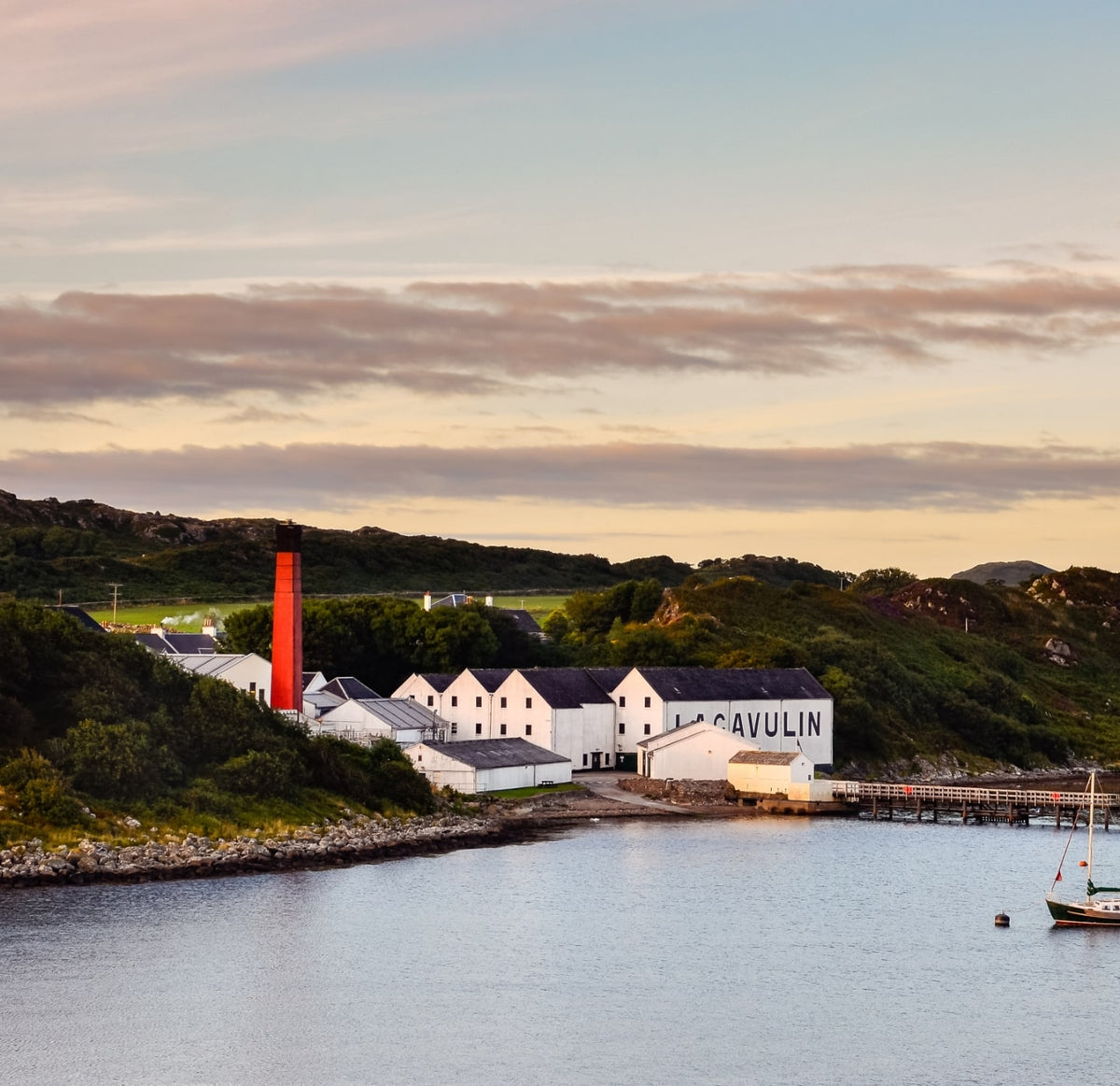 Islay coast with a white building next to a body of water and red chimney